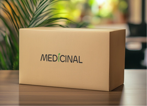 Cardboard box labeled "MEDICINAL" on a wooden table, with a blurred green plant in the background.
